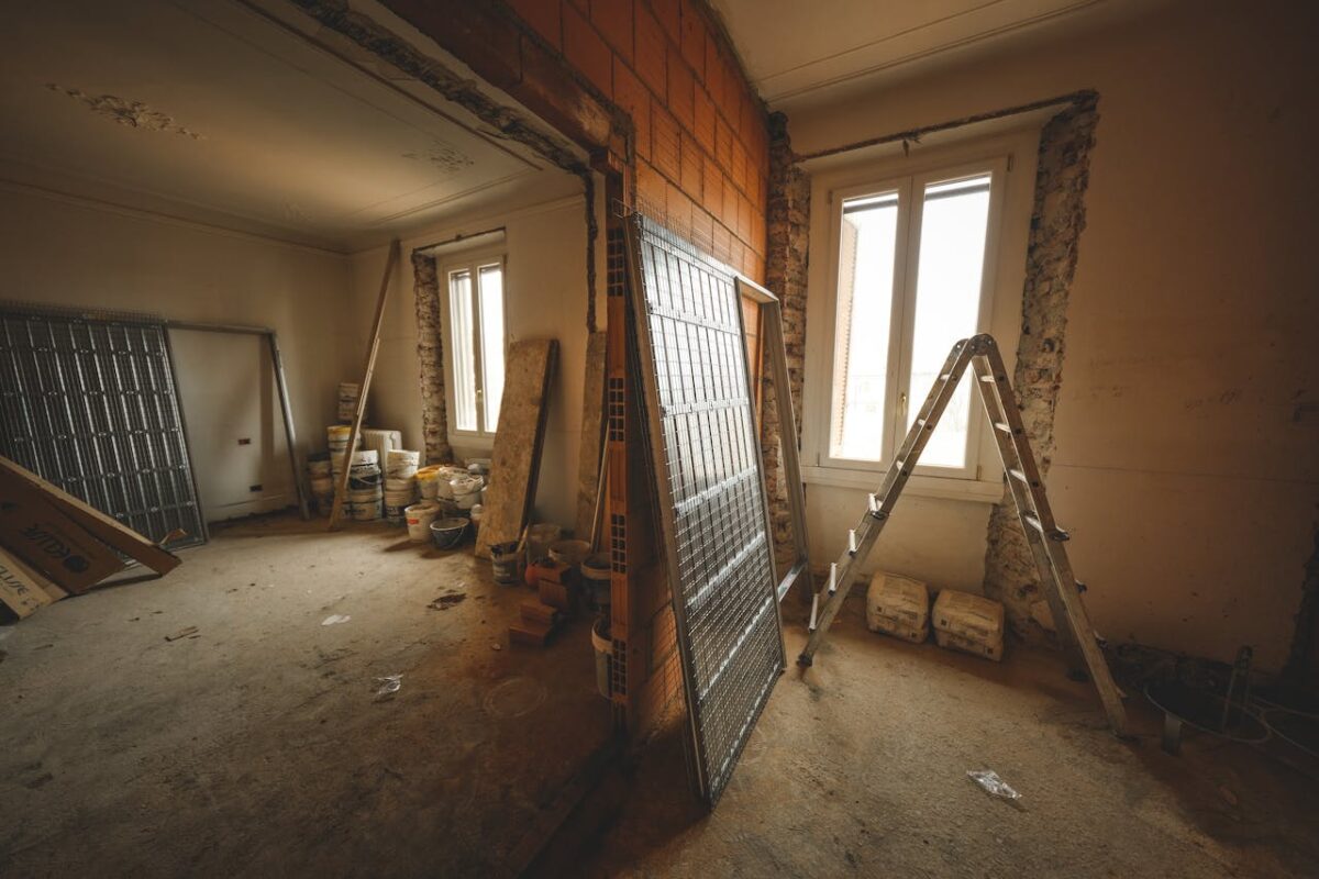 Interior view of a room under renovation with construction materials and a ladder.